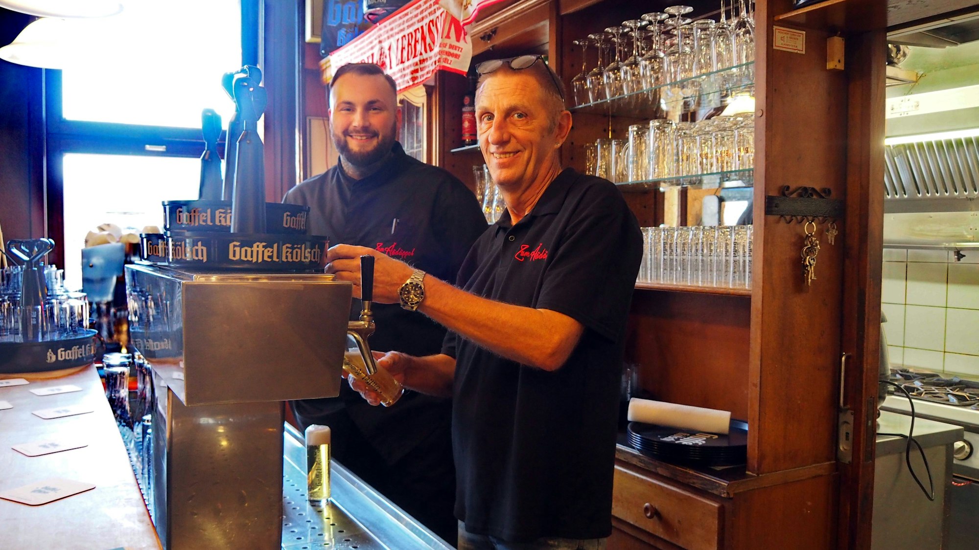 Die zwei Inhaber des neuen Restaurants in Zollstock, Jérôme Lottner und Ralf Klein, stehen hinter dem Tresen aus Holz an der Zapfanlage.