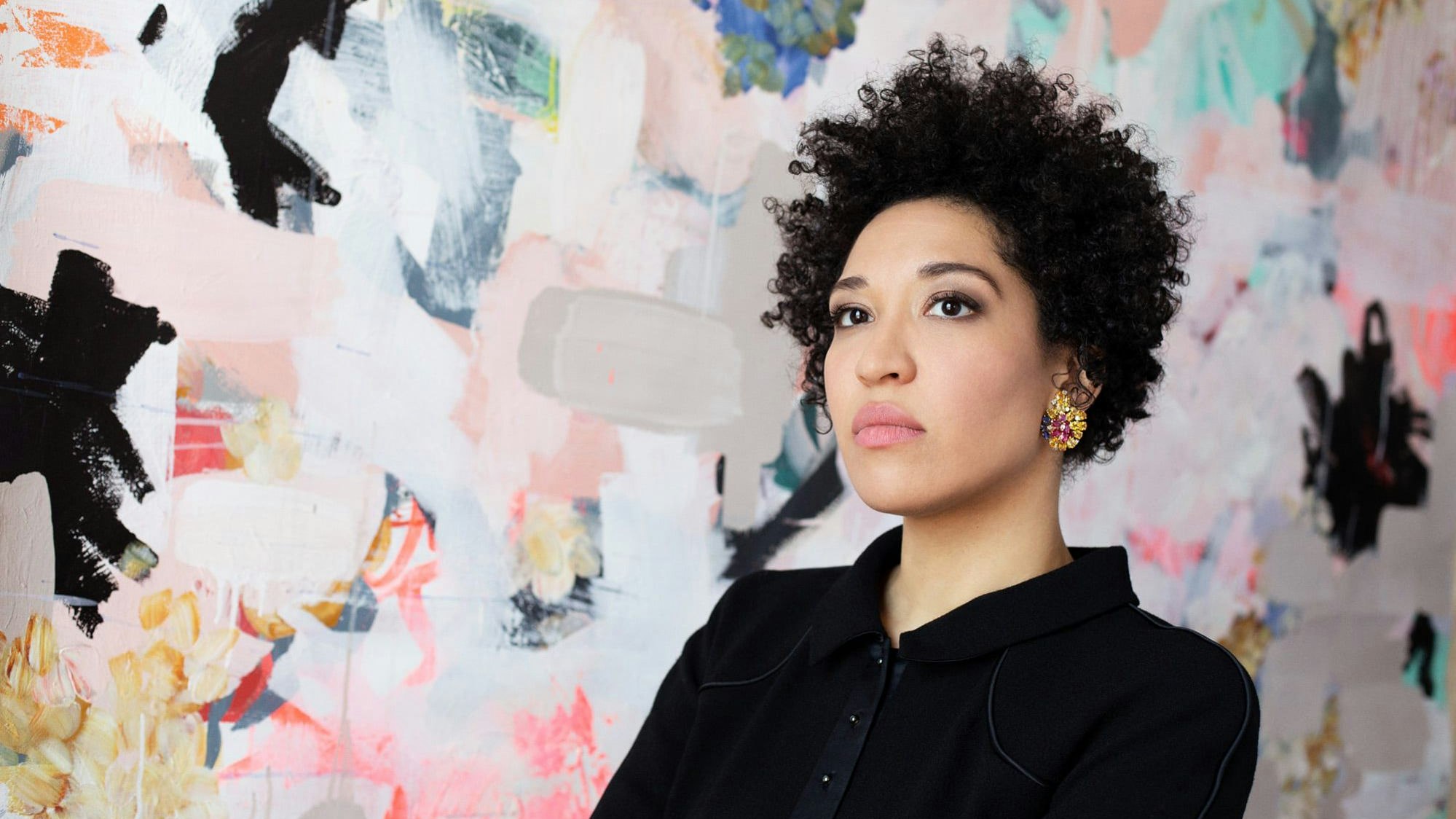 Julia Bullock steht vor einer bunten Tapete.