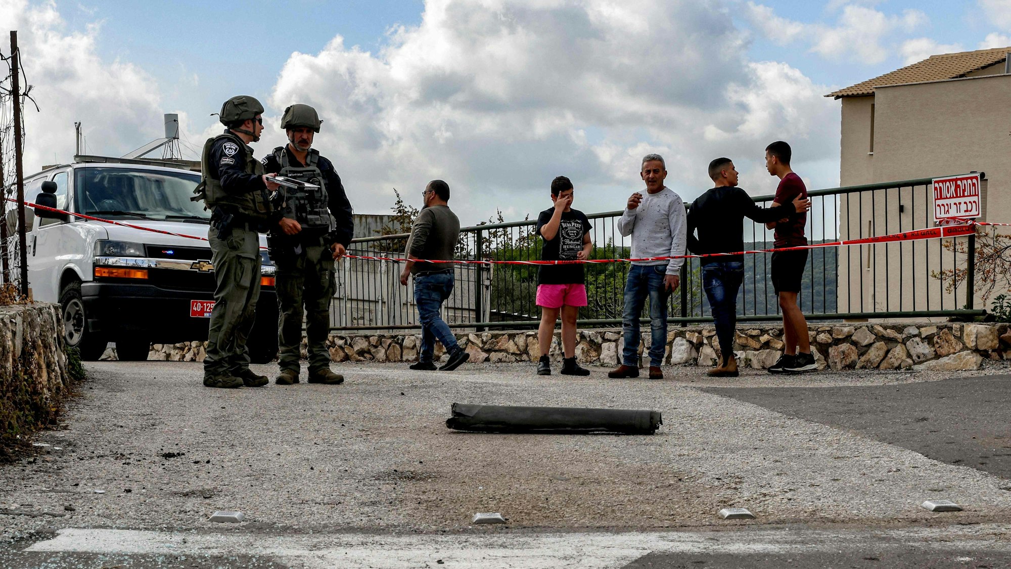 Ein israelisches Bombenkommando und Zivilisten stehen in der nördlich gelegenen Stadt Fassuta bei den Überresten einer aus dem Libanon abgefeuerten Rakete.