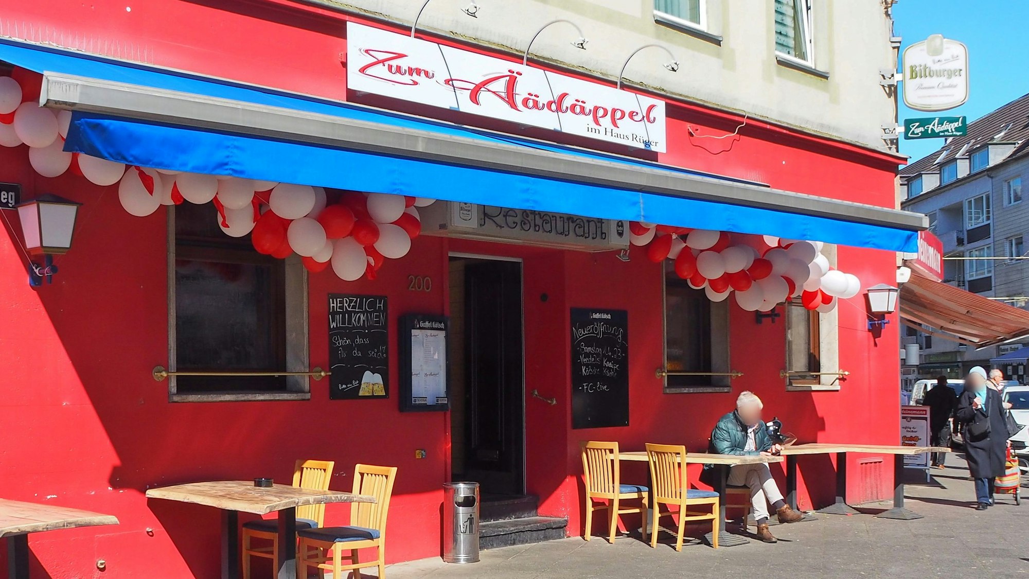 Das rot gestrichene neue Lokal „Zum Äädäppel“ in Zollstock ist zur Eröffnung mit rot-weißen Luftballons geschmückt.