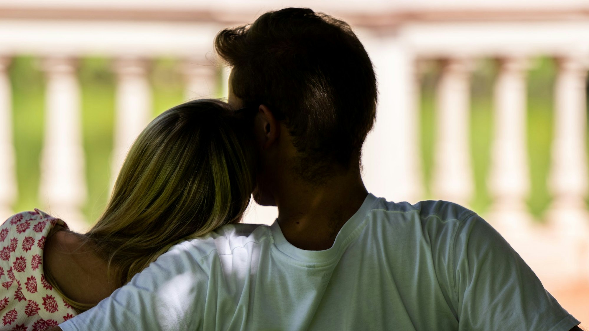 Eine Frau und ein Mann sitzen zusammen auf einer Parkbank.