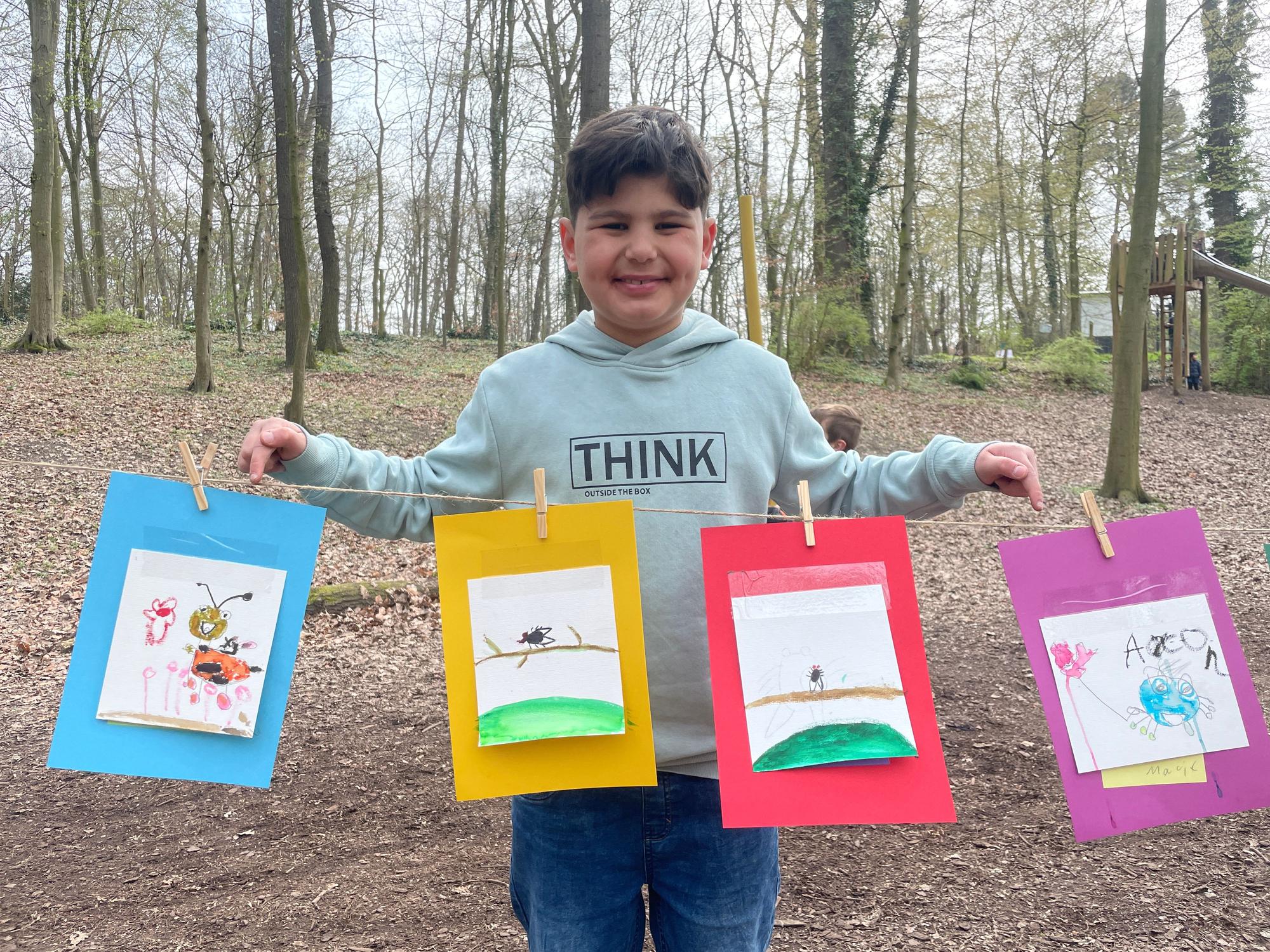 Malik, Schüler an der Grundschule OGS Im Steinfeld, präsentiert stolz seine gemalten Tiere.