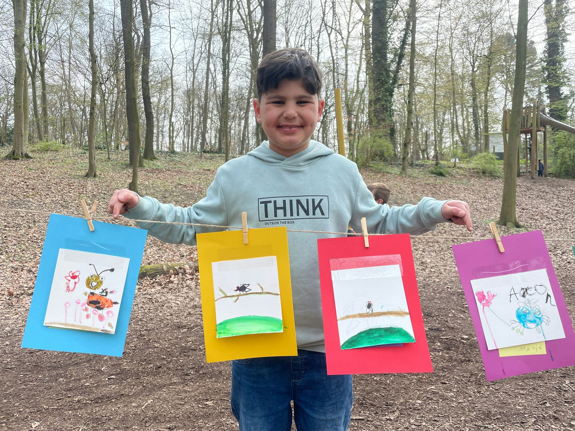 Malik, Schüler an der Grundschule OGS Im Steinfeld, präsentiert stolz seine gemalten Tiere.