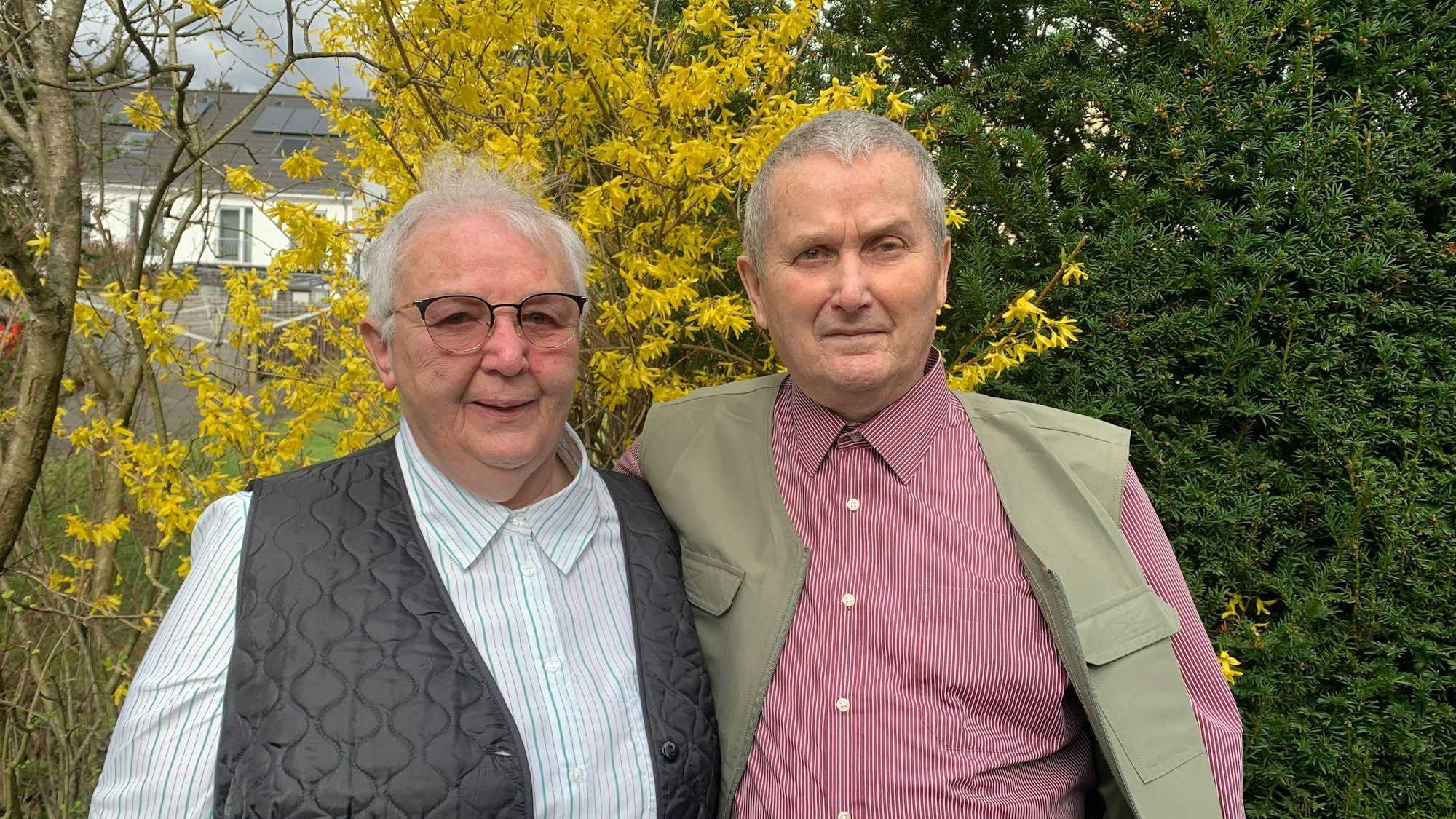 Irma (l.) und Hermann (r.) Neumann halten sich im Arm und blicken in die Kamera.