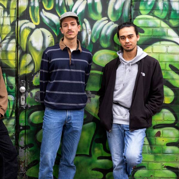 Philipp Schmid, Ben Werchohlad und Eric Wieben stehen vor einer grün besprayten Wand