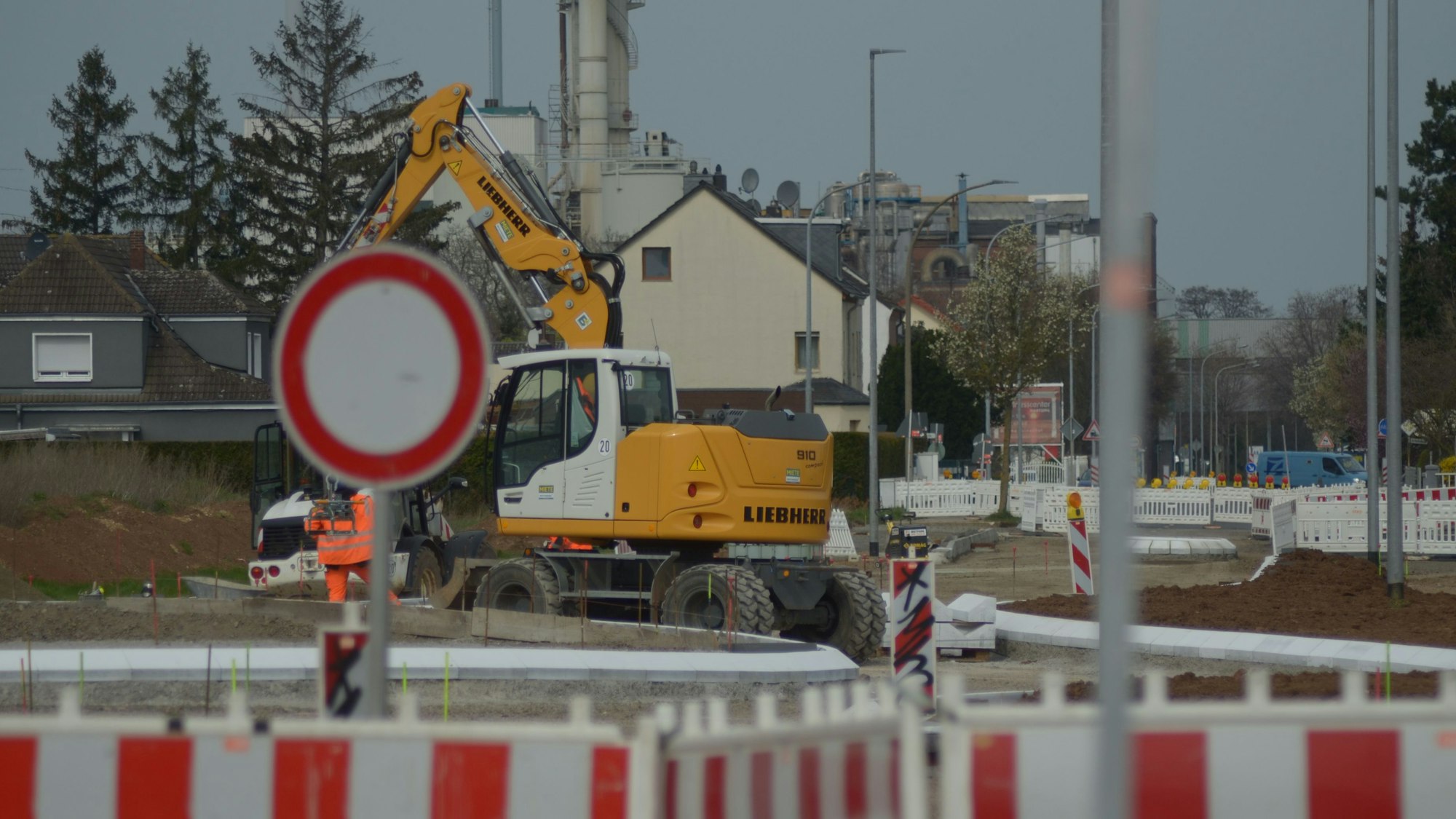 Blick auf die Baustelle. Ein Bagger steht in der Mitte.
