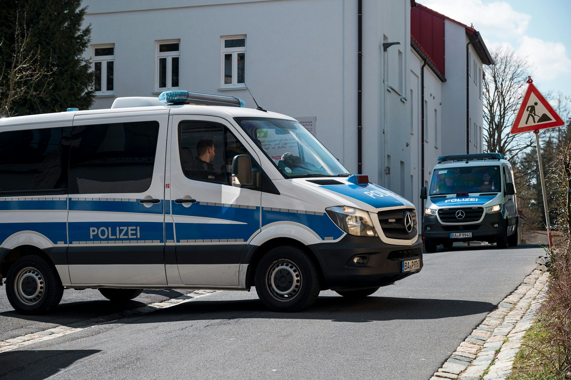 06.04.2023, Bayern, Wunsiedel: Ein Einsatzwagen der Polizei sperrt die Straße zum Kinder- und Jugendhilfezentrum ab.  Ein zehnjähriges Mädchen war in dem Kinder- und Jugendhilfezentrum tot aufgefunden worden. Das Kind ist nach Einschätzung der Staatsanwaltschaft gewaltsam ums Leben gekommen. Foto: Daniel Vogl/dpa +++ dpa-Bildfunk +++