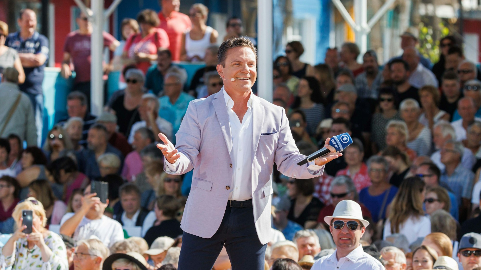 Stefan Mross steht im Vorfeld der Liveübertragung der Show „Immer wieder sonntags“ in der neuen Showarena. Im Hintergrund sieht man das Publikum