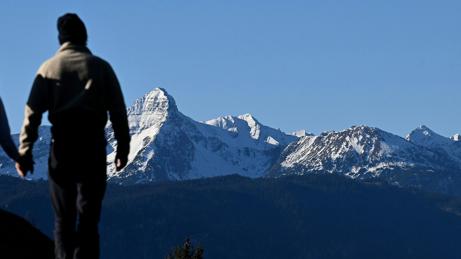 Verschneit zeigt sich der Gipfel des Daniel vor zwei Wanderern. In den deutschen Alpen sind zur Jahreswende weniger Touristen angekommen als vor der Corona-Pandemie. 878 000 Übernachtungsgäste in den Monaten Dezember 2022 und Januar 2023 bedeuteten ein Minus von knapp 13 Prozent gegenüber dem gleichen Zeitraum 2019/2020, wie das Statistische Bundesamt am Dienstag berichtete (zu dpa «Tourismus in den Alpen: Immer noch weniger Gäste als vor Corona»)
