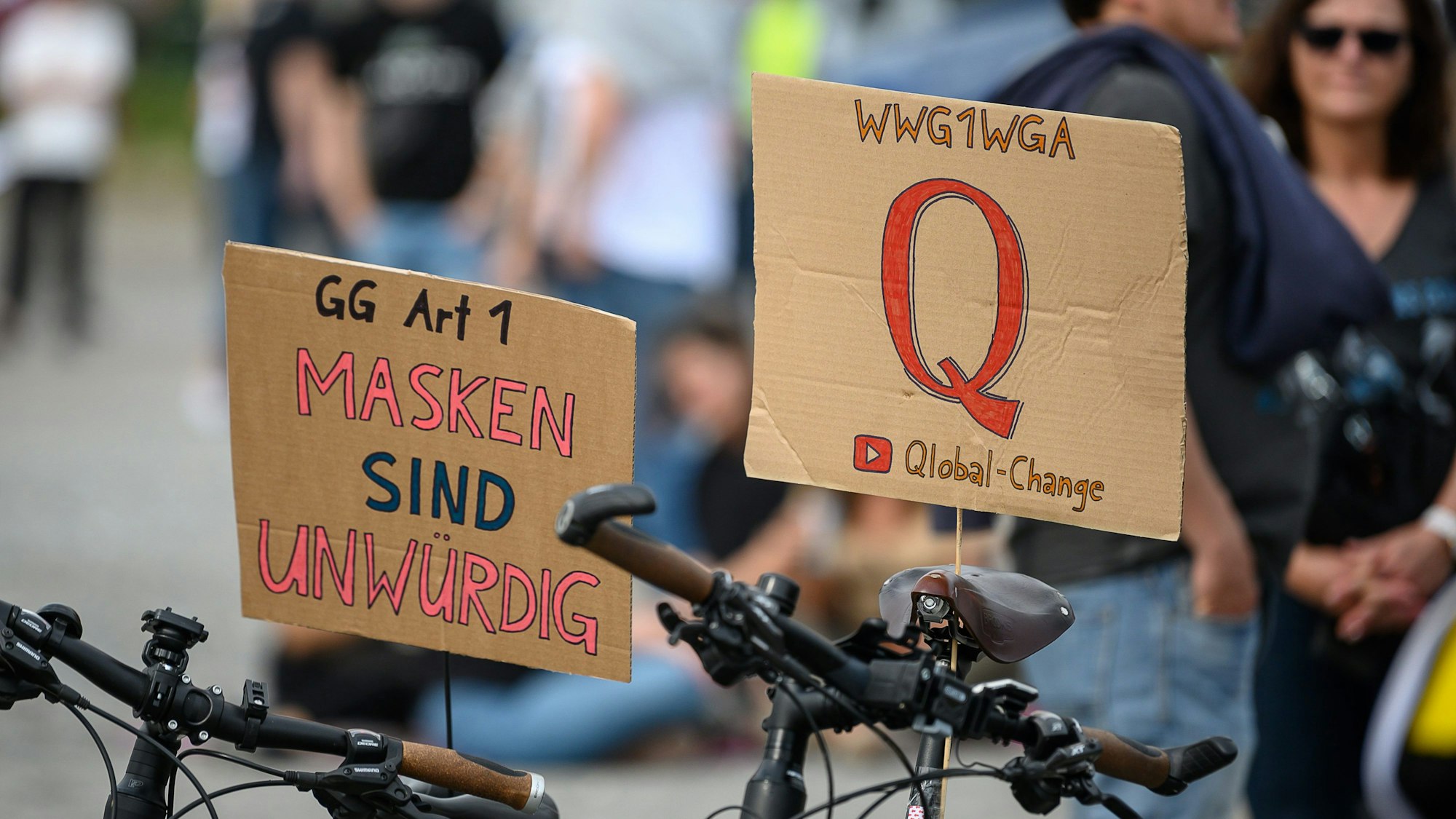 Schilder auf einer Protestkundgebung der Initiative „Querdenken 711“ in Stuttgart. Das „Q“ steht für die Verschwörungstheorie „QAnon“, die aus den USA stammt. „WWG1WGA“ ist ein Slogan von QAnon und steht für „Where We Go One We Go All.“ (deutsche ungefähre Übersetzung: „Wohin wir gehen, gehen wir alle“).