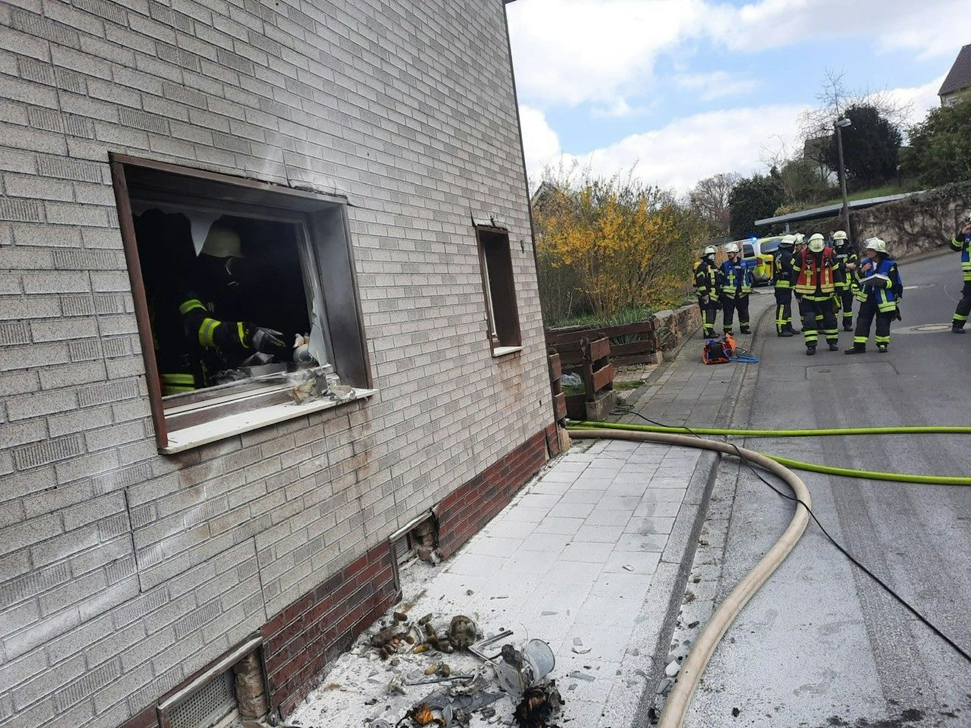 Feuerwehrleute stehen im Hintergrund einer ausgebrannten Küche