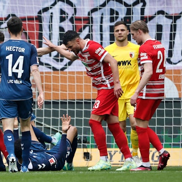 Im Bundesliga-Spiel zwischen dem 1. FC Köln und dem FC Augsburg liegt der Kölner Spieler Davie Selke am Boden. Um ihn herum rangeln unter anderem Jonas Hector, Jeff Chabot vom 1. FC Köln und Maximilian Bauer und Jeffrey Gouweleeuw vom FC Augsburg.