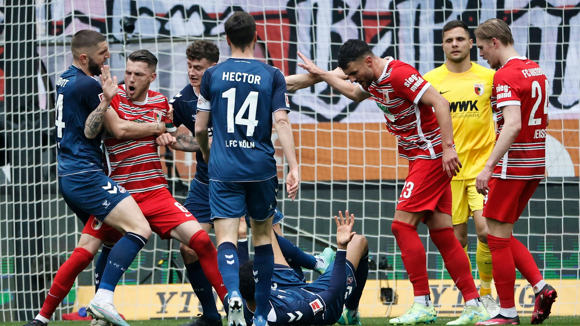 Im Bundesliga-Spiel zwischen dem 1. FC Köln und dem FC Augsburg liegt der Kölner Spieler Davie Selke am Boden. Um ihn herum rangeln unter anderem Jonas Hector, Jeff Chabot vom 1. FC Köln und Maximilian Bauer und Jeffrey Gouweleeuw vom FC Augsburg.