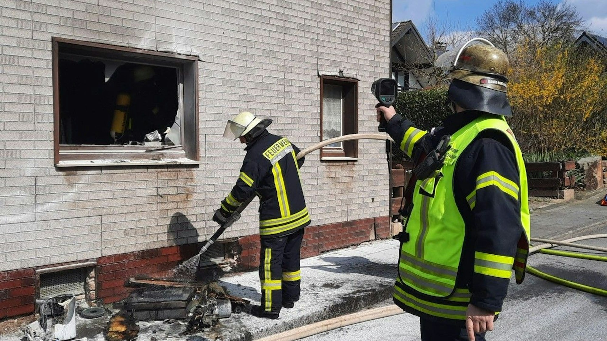 Zwei Feuerwehrkräfte löschen einen Küchenbrand.