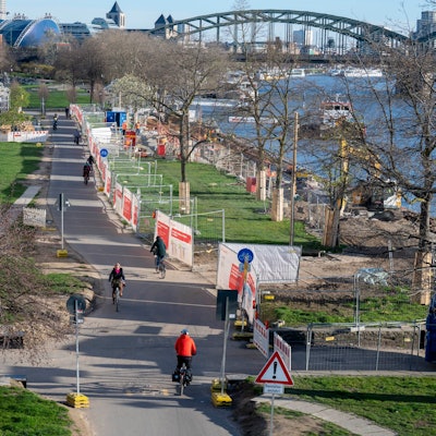 Der Ist-Zustand im Rheingarten: Bauarbeiten an der Kragplatte, eine asphaltierte Straße für Radfahrer mitten durch die Rasenfläche
