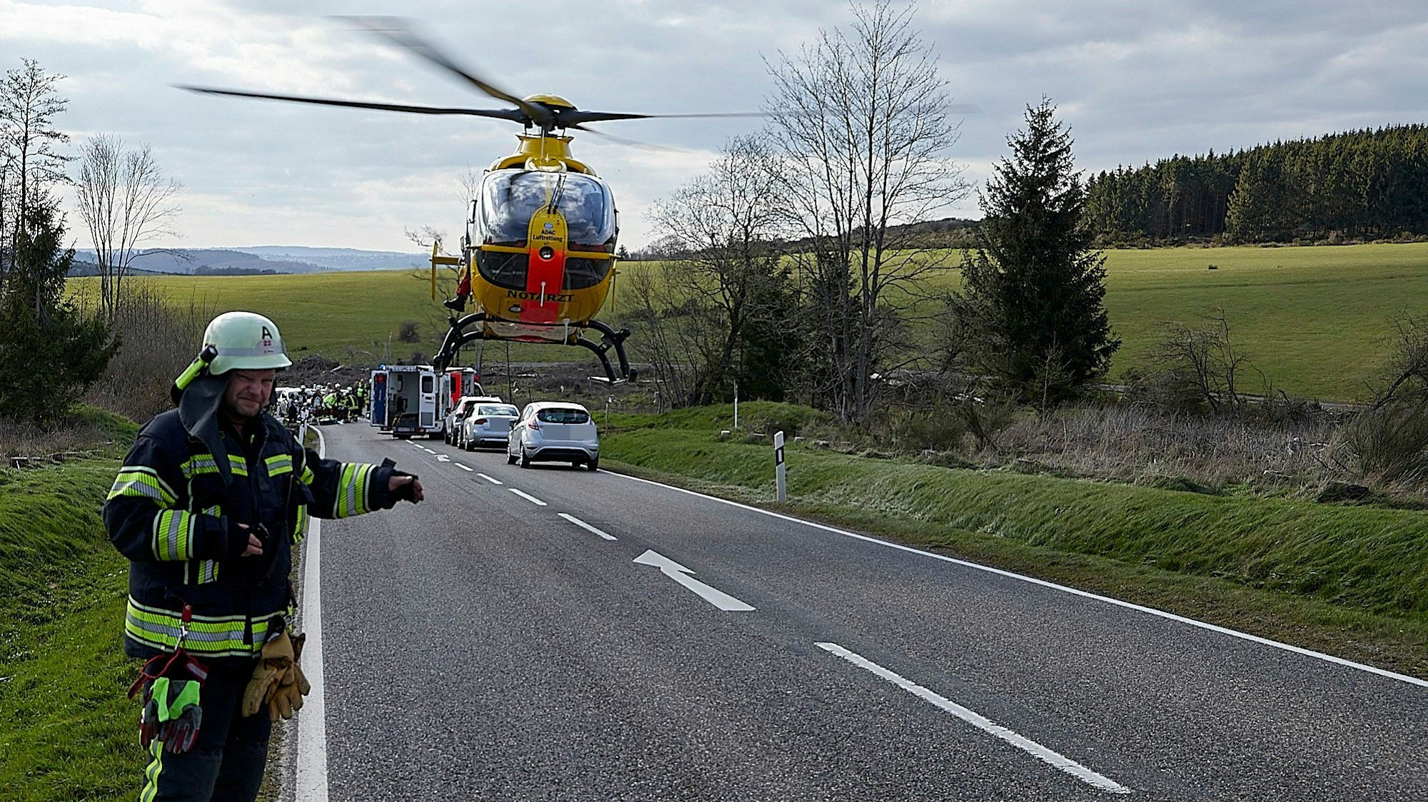 Ein Feuerwehrmann weist dem tief anfliegenden Rettungshubschrauber die Landestelle.