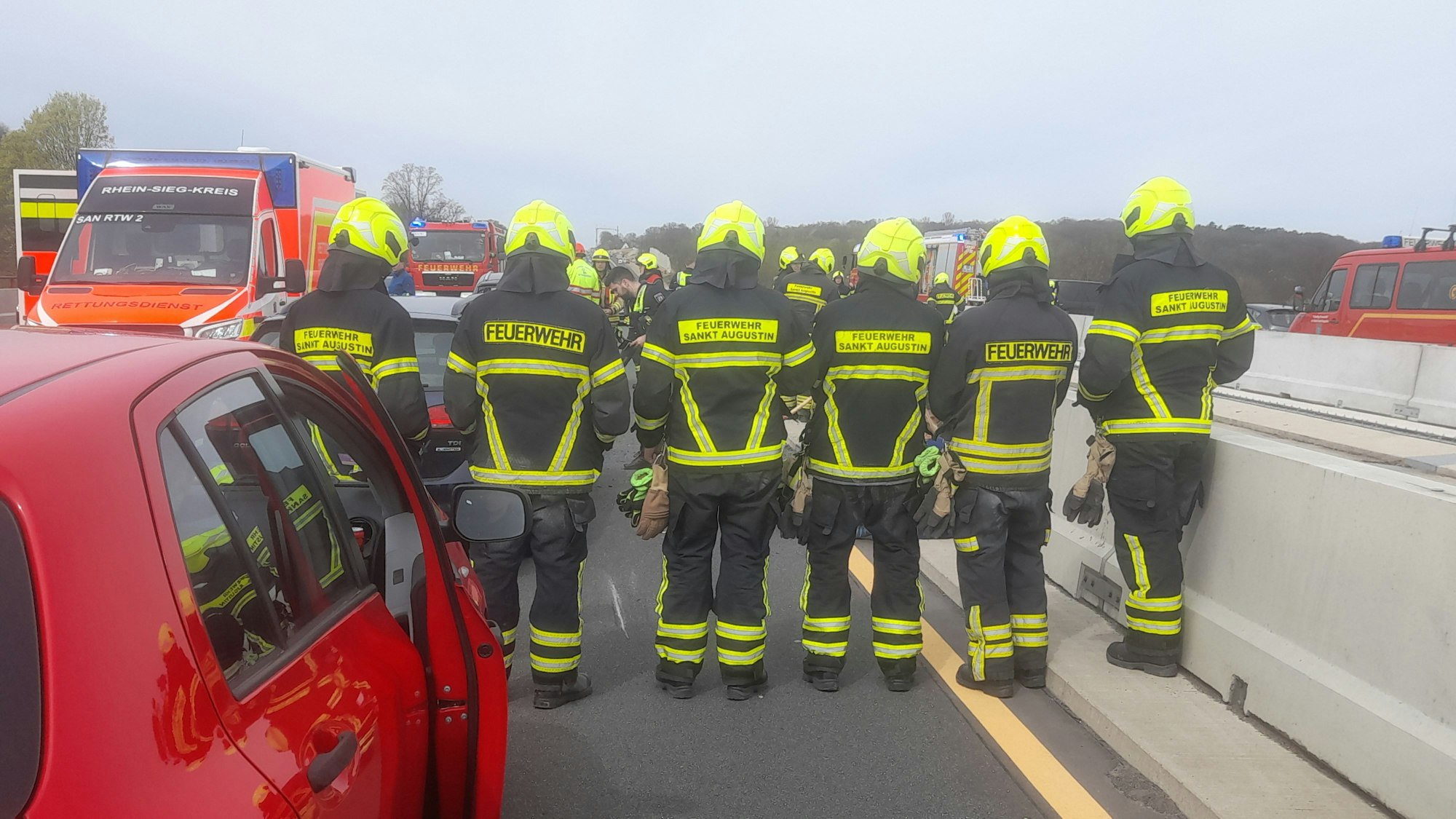 Feuerwehrleute bilden einen Sichtschutz.