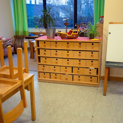 Blick in den Raum einer Kindertagesstätte mit hochgestellten Stühlen.