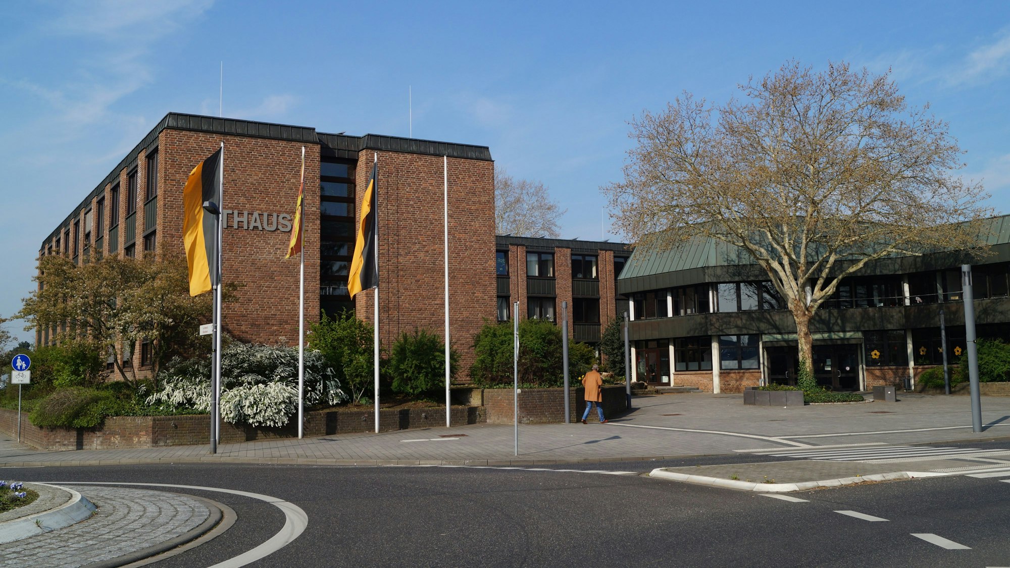 Das Rathaus Kerpen steht im Mittelpunkt des Bildes, im unteren Teil des Bildes ist ein Kreisverkehr zur Hälfte sichtbar, rechts im Bild findet sich ein Baum.
