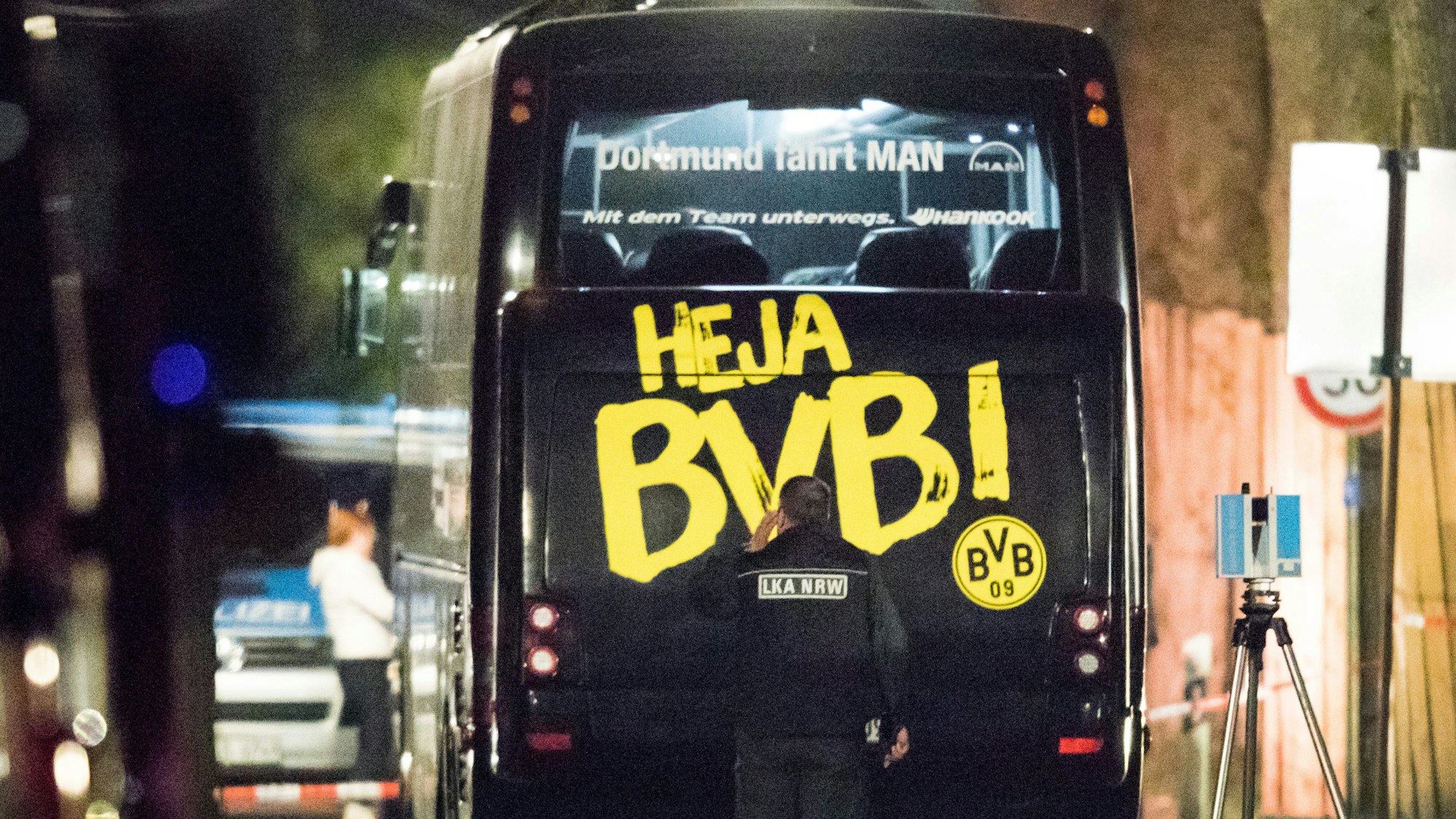 Ein Beamter des Landeskriminalamtes (LKA) untersucht in der Nacht nach dem Anschlag den Mannschaftsbus der Fußballmannschaft von Borussia Dortmund.