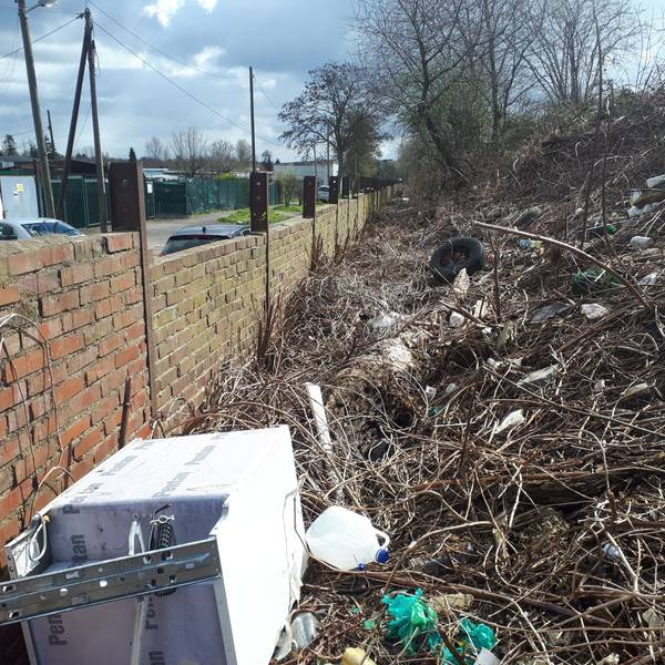 Eine alte Waschmaschine, Plastikkanister, Autoreifen und sonstiger Unrat türmt sich hinter einer Bahndamm-Mauer an der Etzelstraße.