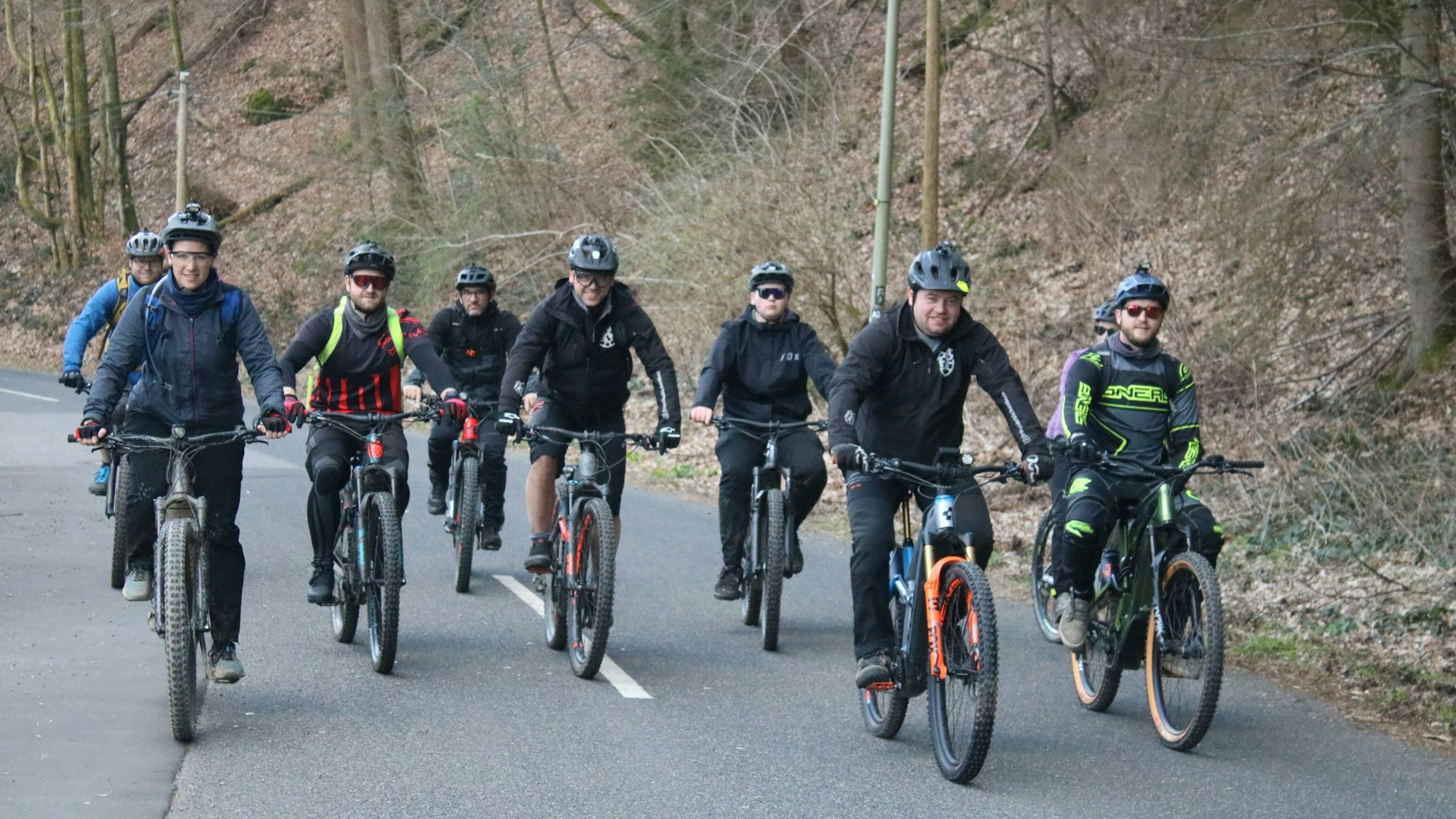 Mehrere Radfahrer sind als Gruppe auf einer Straße unterwegs.