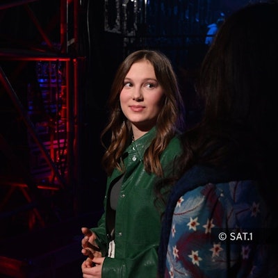 Eine Jugendliche steht auf einer Bühne.