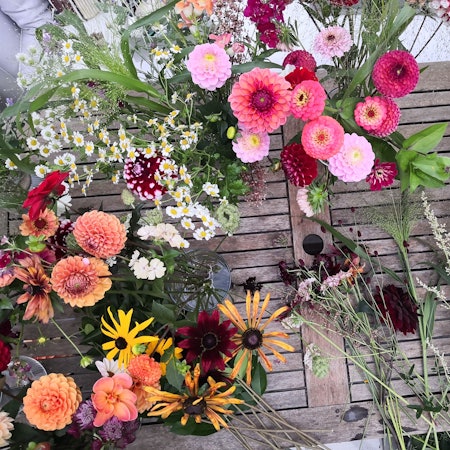 Blumen liegen bei Rheinblüten auf einem Tisch und stehen in Vasen.