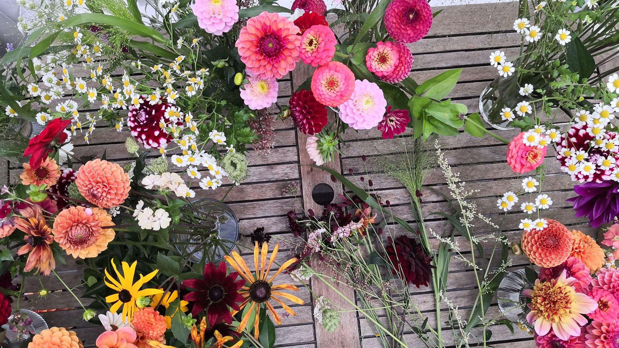 Blumen liegen bei Rheinblüten auf einem Tisch und stehen in Vasen.