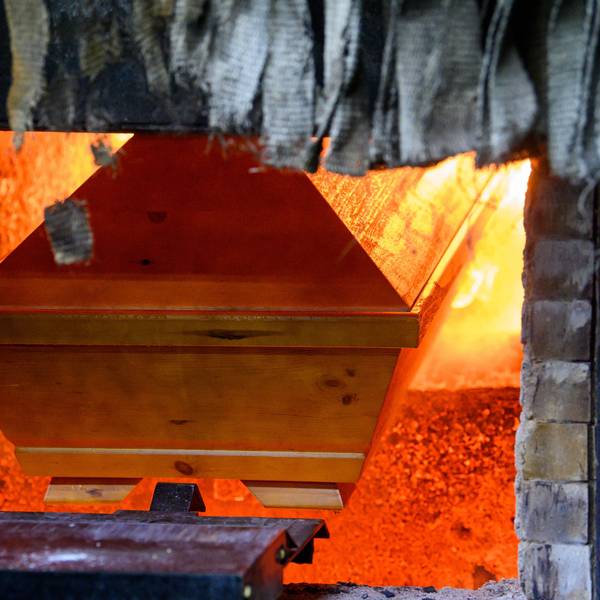 Ein Sarg wird in einem Krematorium in den Einäscherungsofen eingefahren.