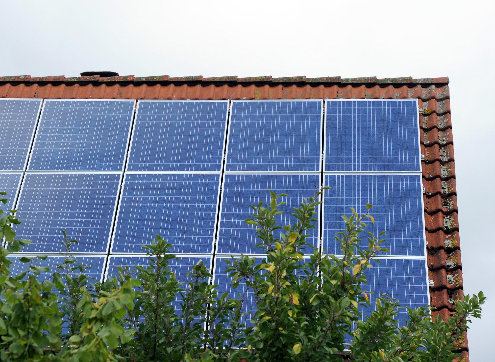 Ein Dach ist mit Photovoltaik-Modulen bestückt.