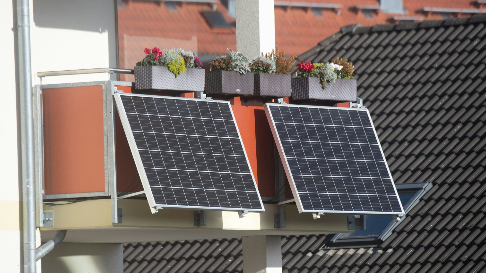 Solarmodule für ein sogenanntes Balkonkraftwerk hängen an einem Balkon.