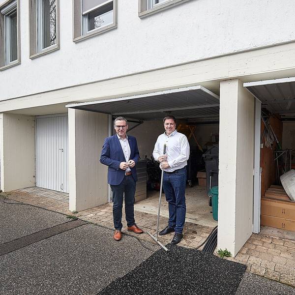 Bürgermeister Norbert Crump (l.) und Stefan Grieshaber stehen vor drei Garagen am Rathaus der Gemeinde Nettersheim in Zingsheim.