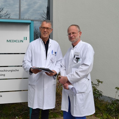 Zwei Ärzte stehen in weißen Kitteln vor dem Eingang der Mediclin-Rehaklinik in Reichshof.