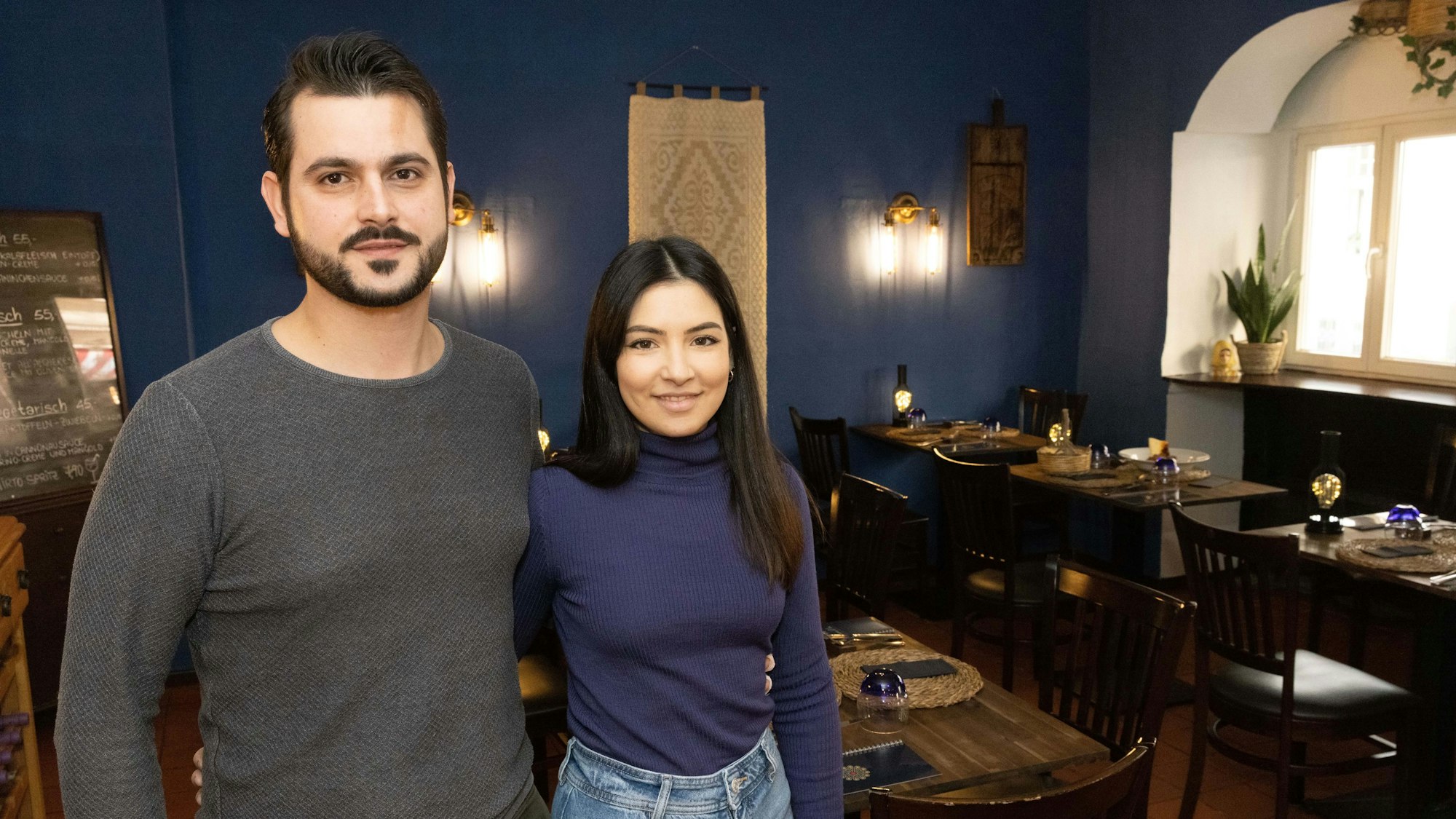 ein Paar steht Arm in Arm in einem Restaurant