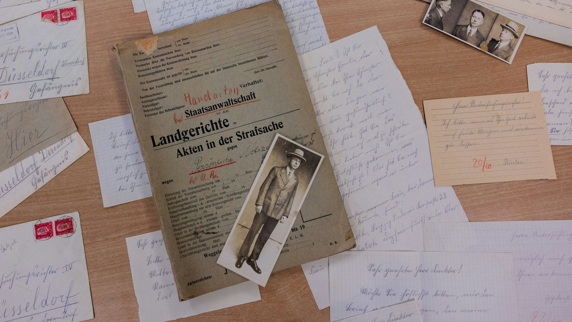 Unterlagen und Fotografien aus der Handakte zum Kriminalfall Peter Kürten liegen im Stadtarchiv auf einem Tisch.