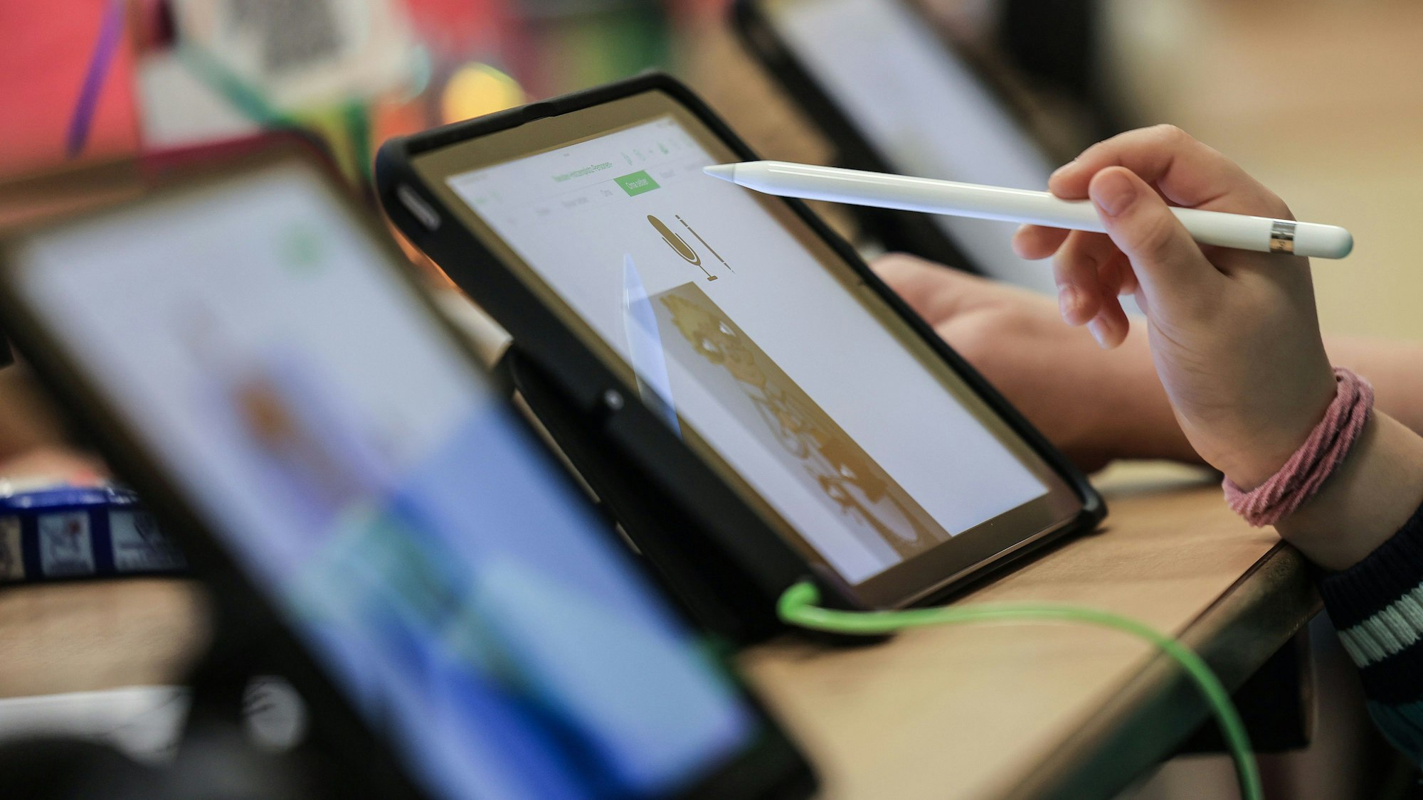 Schüler lernen in einer Klasse in der Grundschule am iPad.