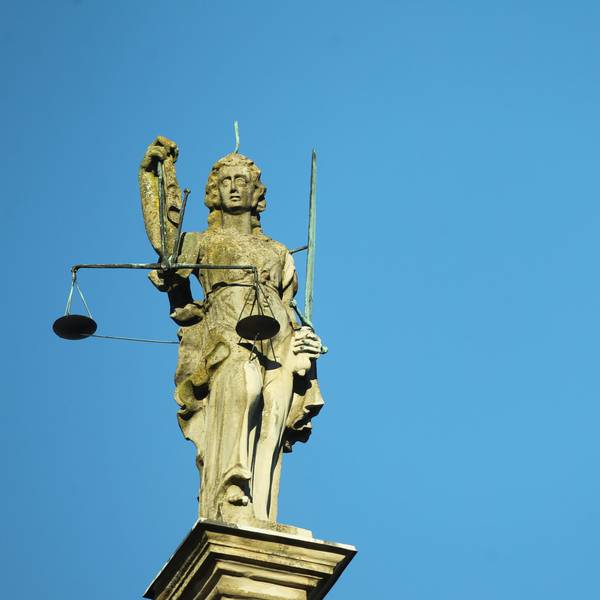 Justitia Statue aus Stein vor blauem Himmel. (Symbolbild)