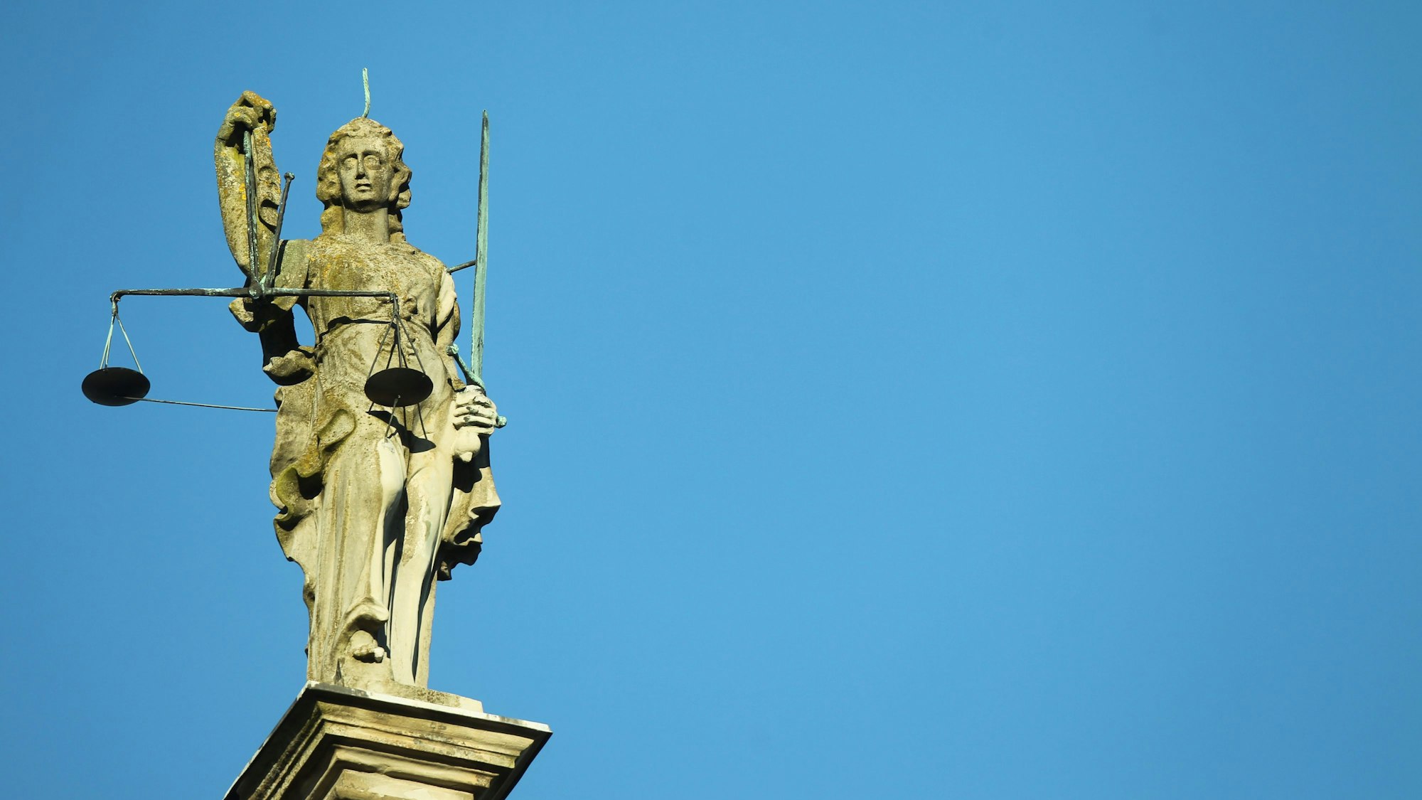 Justitia Statue aus Stein vor blauem Himmel. (Symbolbild)