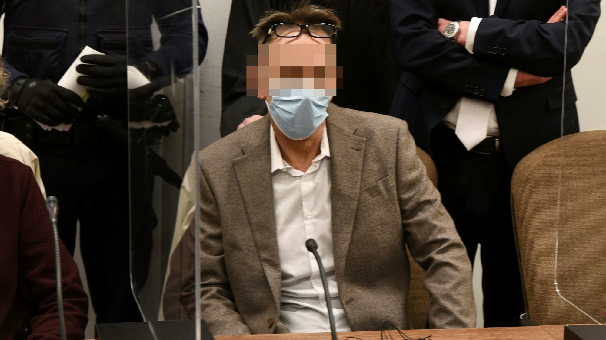 Der Mitangeklagte Eugen W. sitzt mit einer Maske im Gericht.