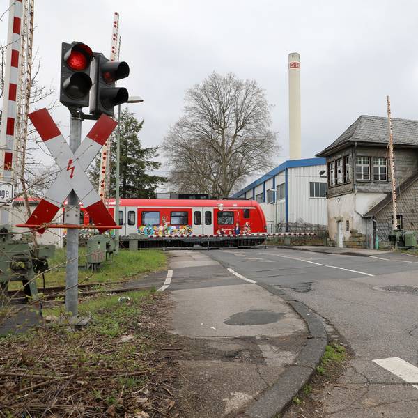 Eine Bahn fährt über den Bahnübergang an der Tannenbergstraße in Bergisch Gladbach.