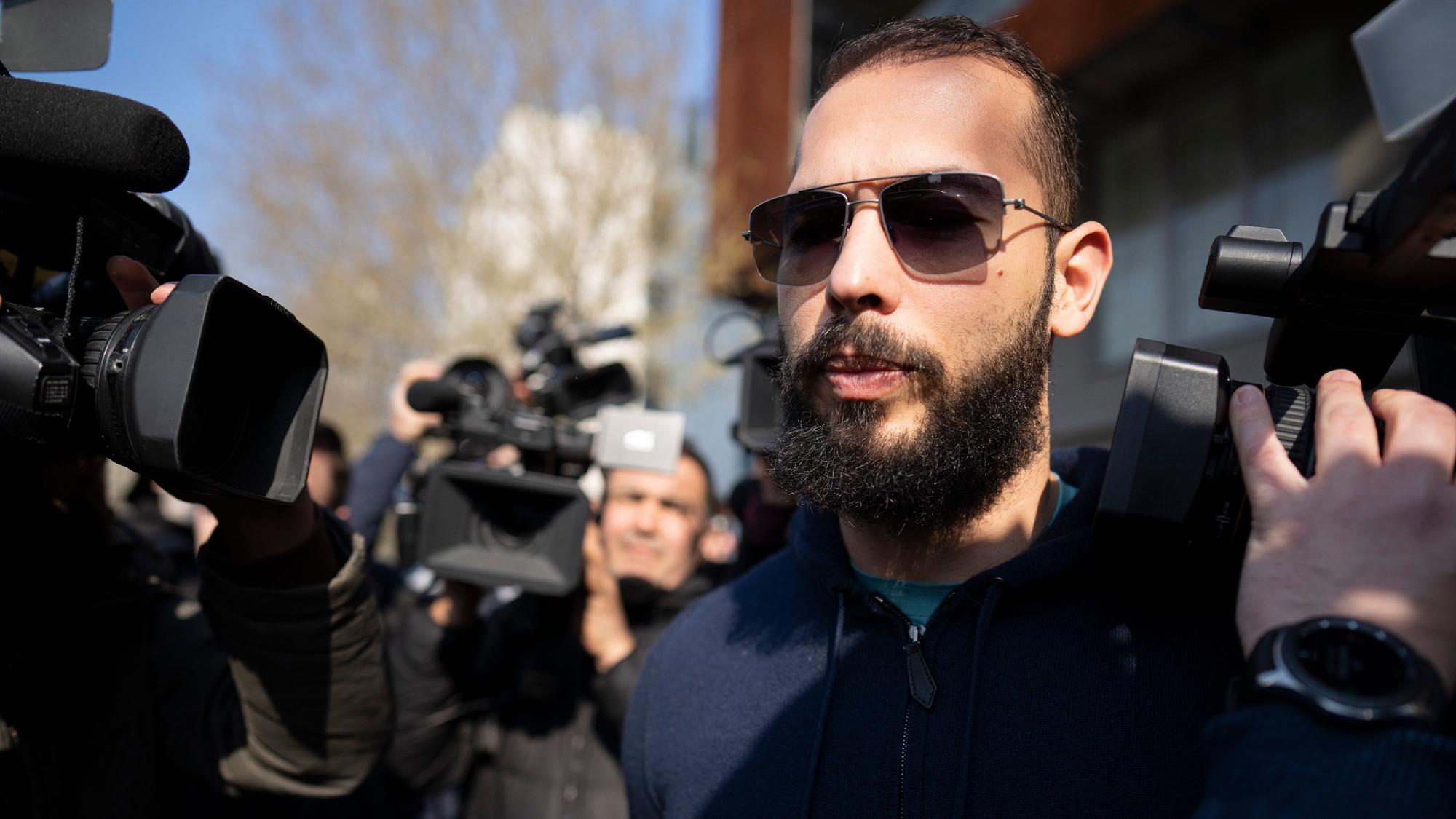 Der frauenfeindliche Andrew Tate mit Sonnenbrille ist von Kameras umringt