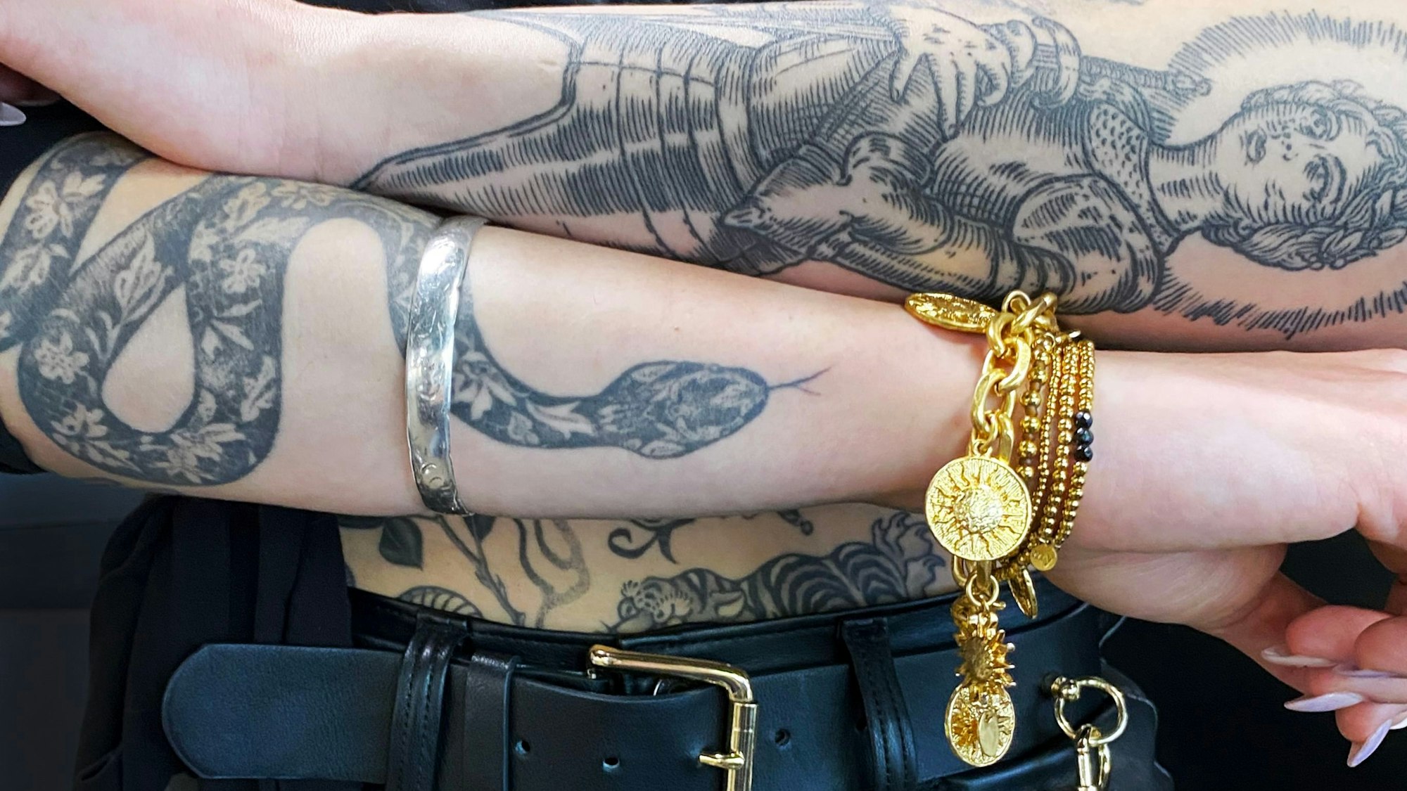 Tattoo-Künstlerin Myriam Black zeigt ihre tätowierten Unterarme.