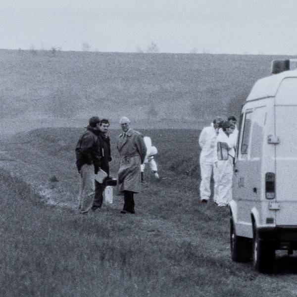Das historische Foto zeigt einen Transporter der Polizei, der auf einem Feldweg steht. Um ihn herum stehen Menschen.