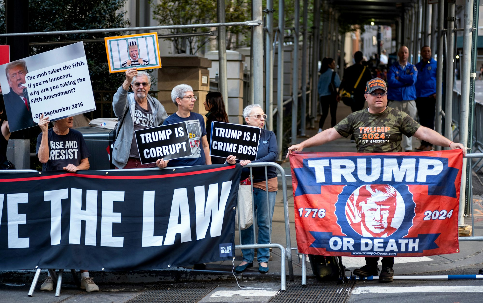 Demonstranten versammeln sich und halten Banner und Plakate, unter anderem mit der Aufschrift „Trump or Death“, bevor der ehemalige US-Präsident Trump am Gebäude des Generalstaatsanwalts ankommt.