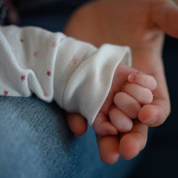 Die Hand eines zwei Wochen altes Neugeborenen liegt in der Hand seiner Mutter. (Symbolbild)