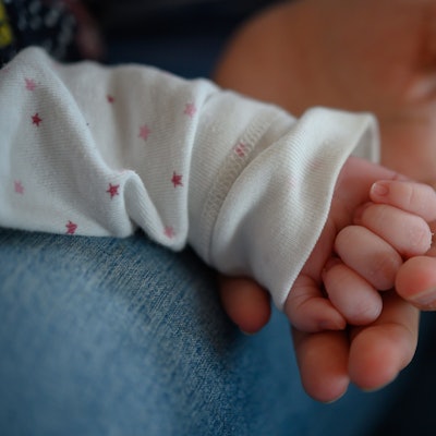 Die Hand eines zwei Wochen altes Neugeborenen liegt in der Hand seiner Mutter. (Symbolbild)