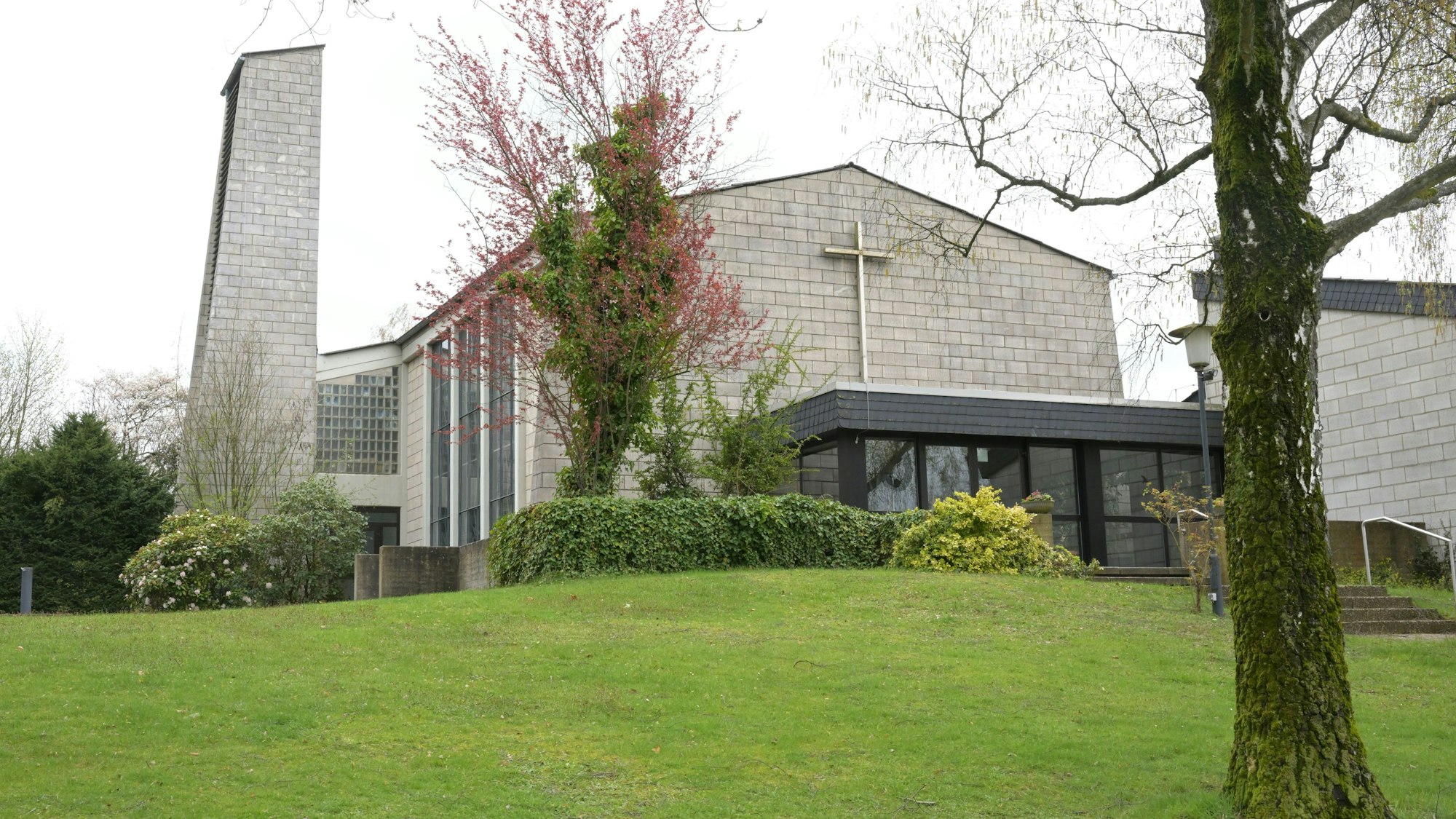 Ein Baum steht vor der Evangelischen Christuskirche Forsbach.