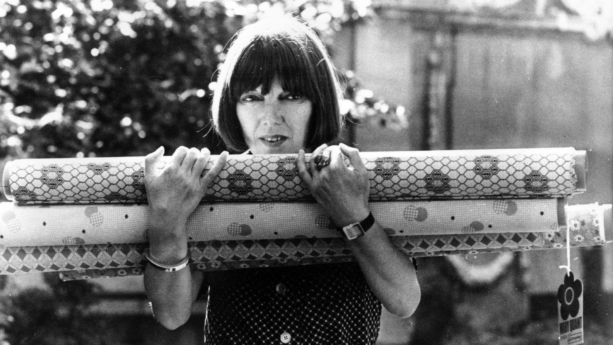 18.09.1974, Großbritannien, London: Mary Quant, Modedesignerin aus Großbritannien, trägt Stoffrollen in ihren Armen, die für ihre neuen Entwürfe verwendet wurden, die sie zuvor im Savoy Hotel gezeigt hatte.