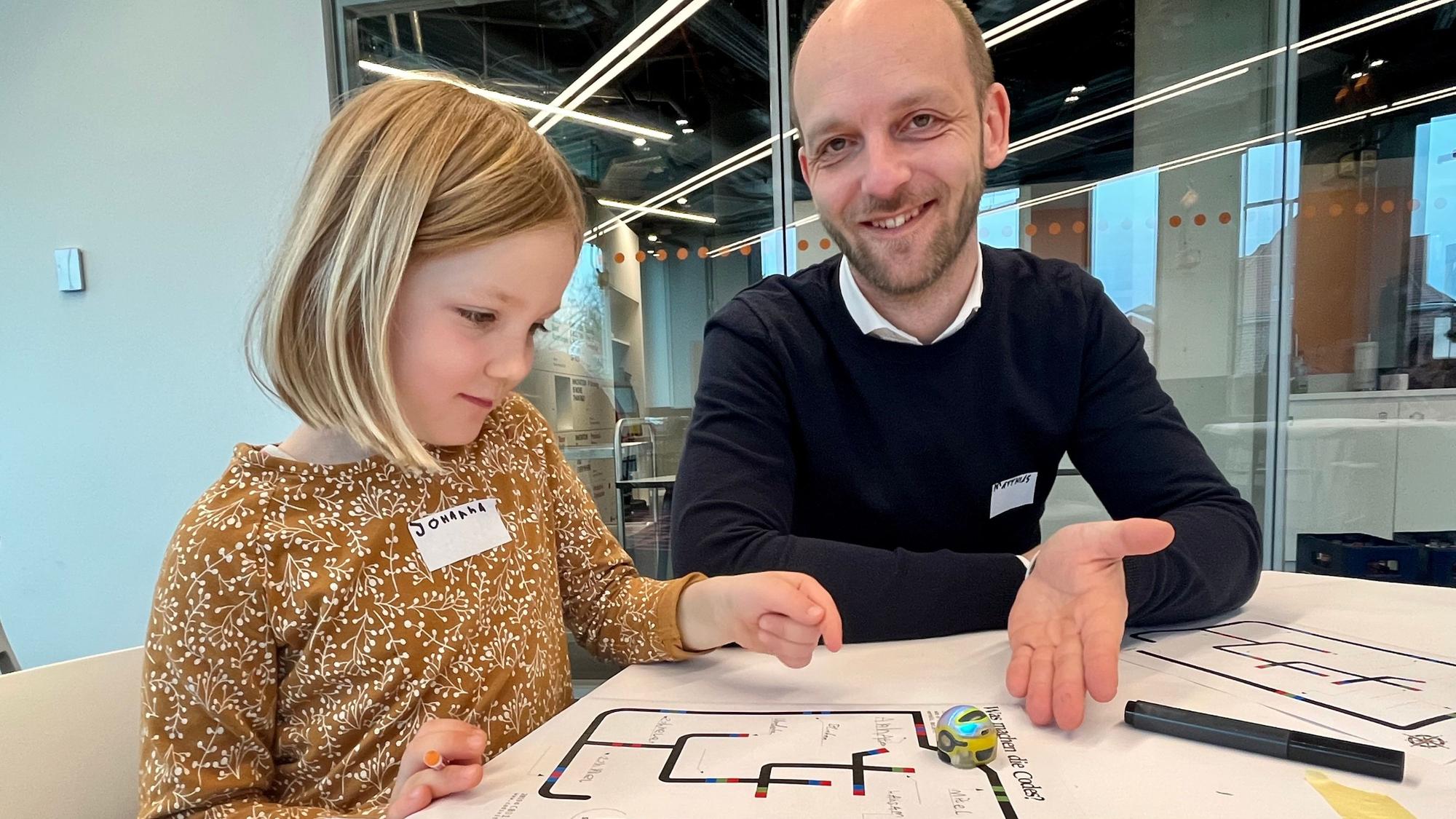 Vater und Tochter lassen den Ozobot fahren